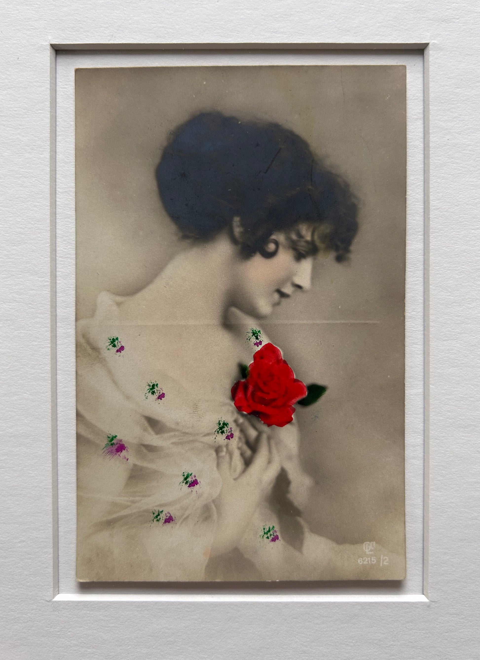 By any other name - Framed 1920s Hand-Colored Postcard featuring a soft portrait of a woman holding a flower – Vintage Parisian Portrait in Merbau wood Frame