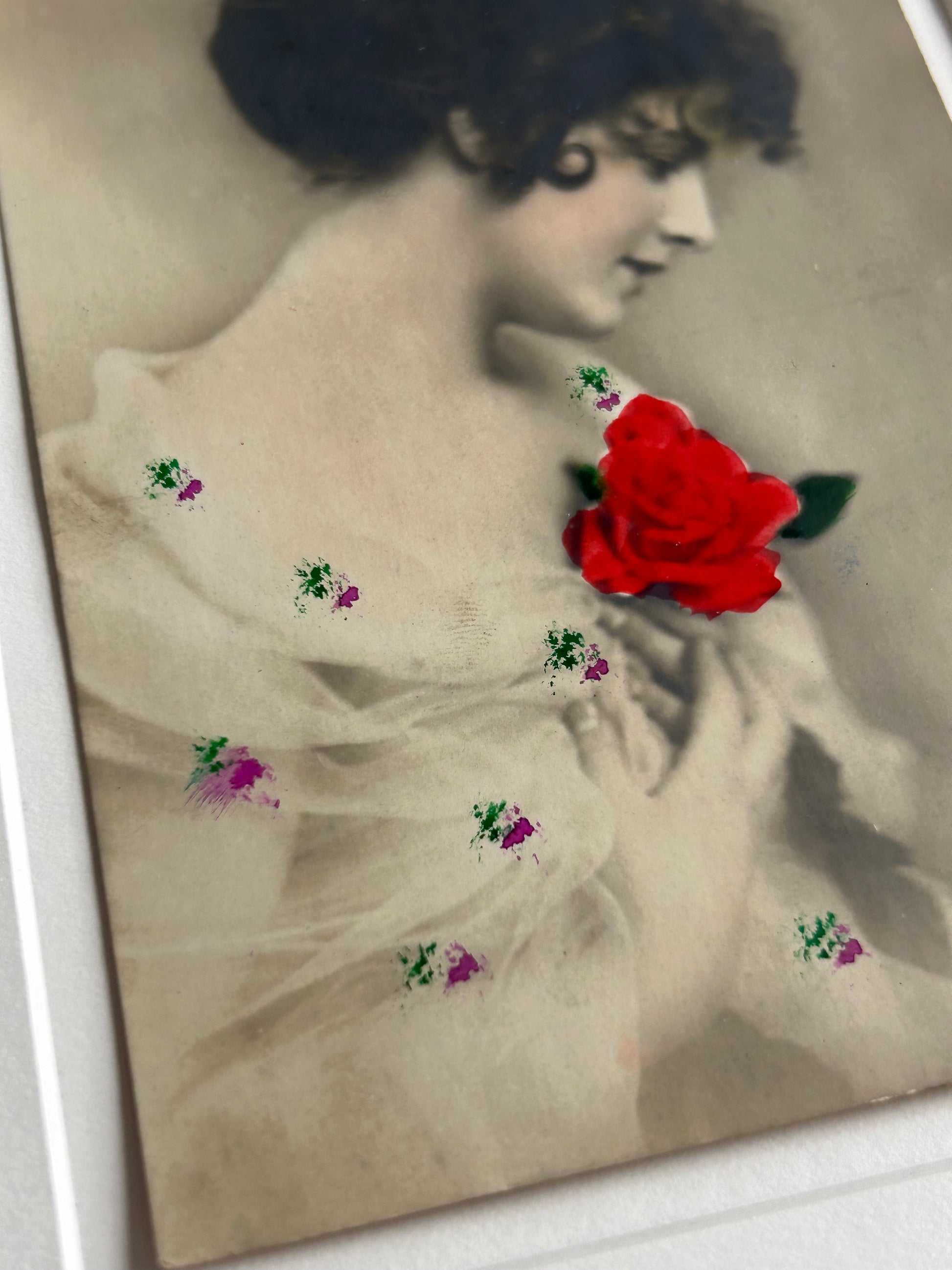 By any other name - Framed 1920s Hand-Colored Postcard featuring a soft portrait of a woman holding a flower – Vintage Parisian Portrait in Merbau wood Frame