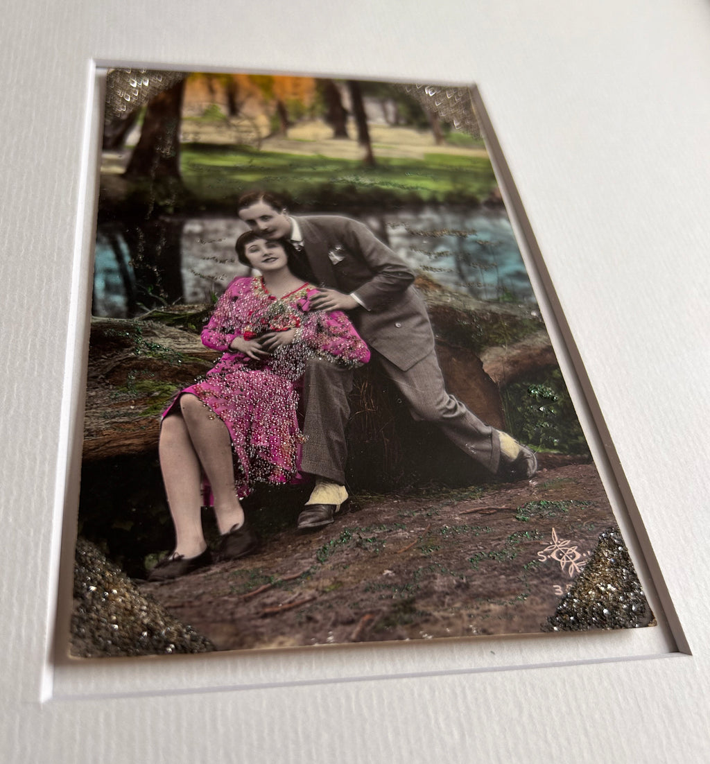 Starts with a great story - Framed 1920s Hand-Tinted and glittered Postcard featuring a tender couple’s embrace in a park – Vintage Romantic Art in Tigerwood Frame