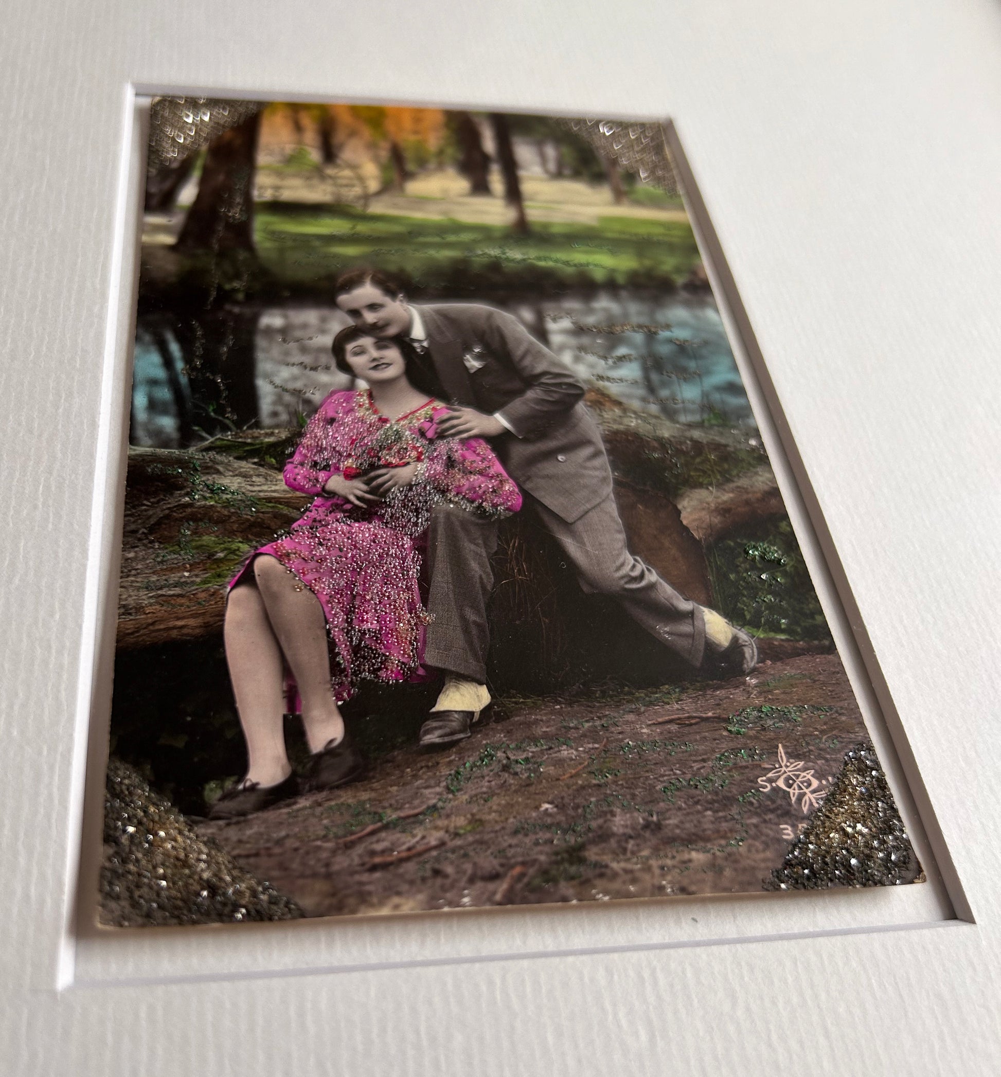 Starts with a great story - Framed 1920s Hand-Tinted and glittered Postcard featuring a tender couple’s embrace in a park – Vintage Romantic Art in Tigerwood Frame